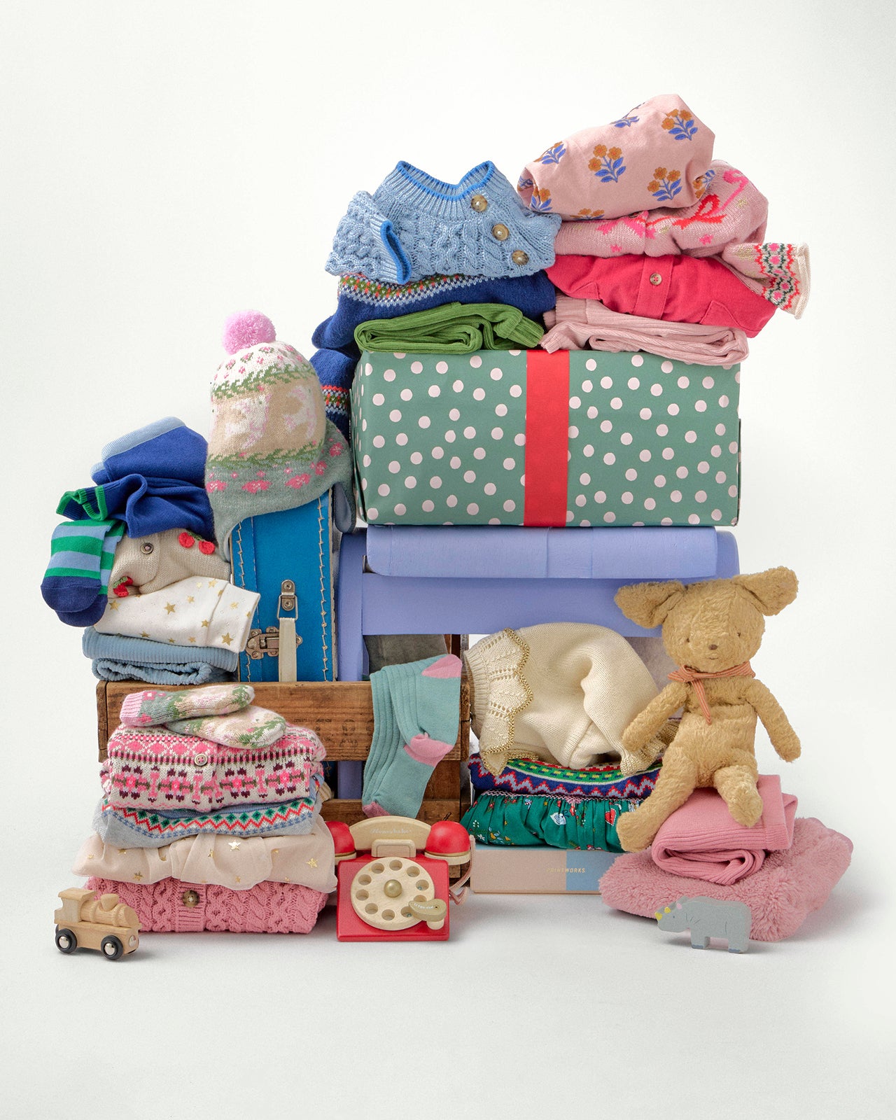 Stack of children's clothes and toys on a white background