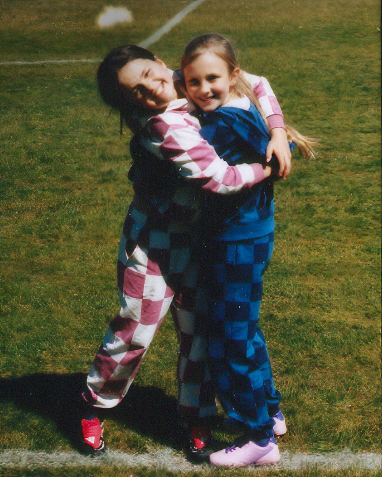 Two people hugging on a grassy field