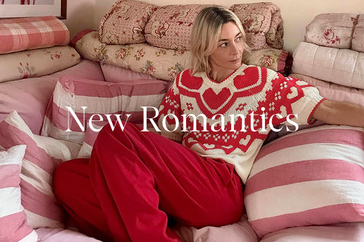 Woman wearing a red and white patterned sweater sitting on a pink couch with 'New Romantics' text overlay.