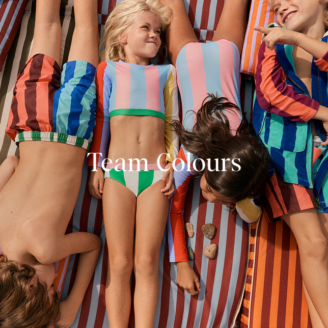 Children wearing colorful striped swimwear with 'Team Colours' text.