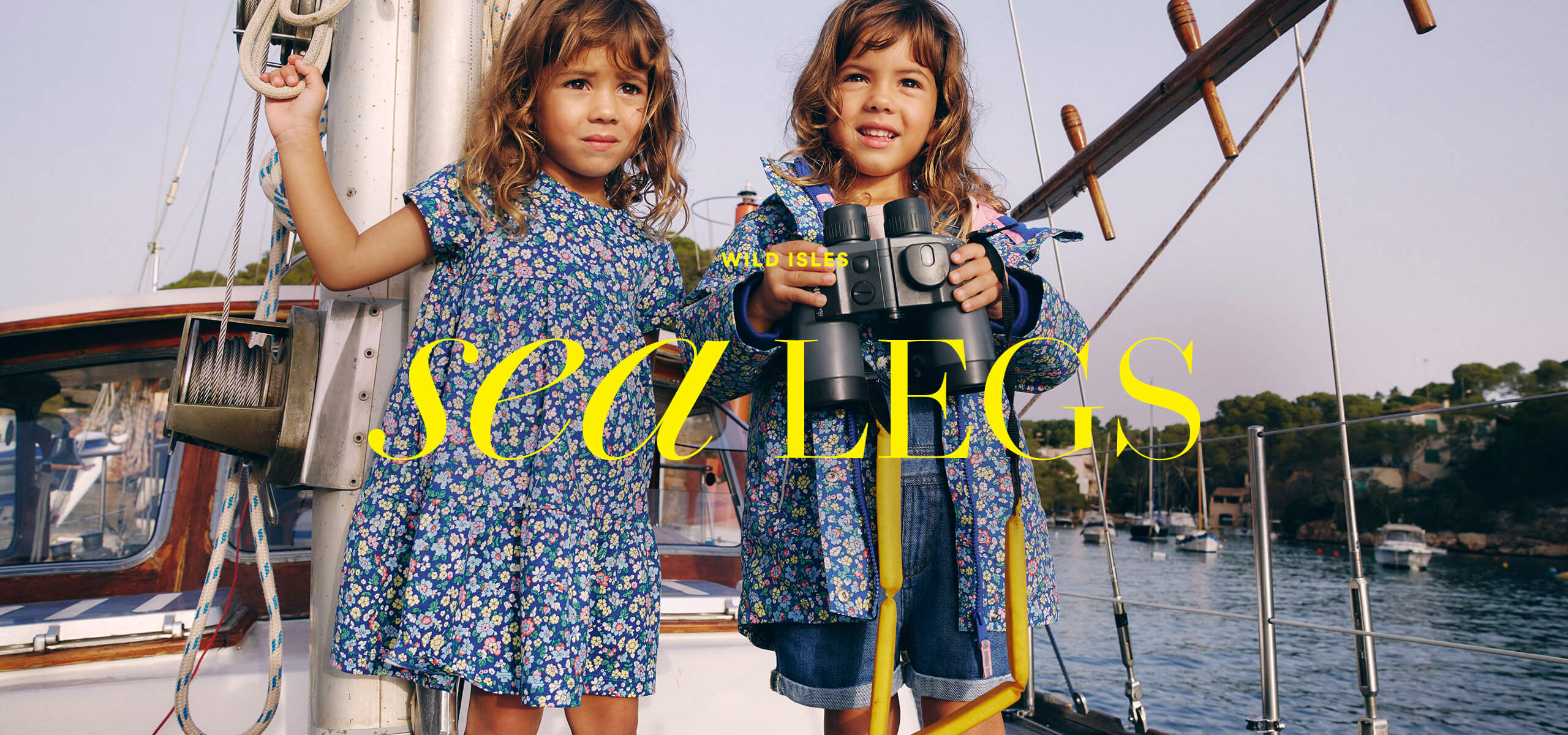 Two girls in matching Boden prints on a boat, caption "Wild Isles: Sea Legs"