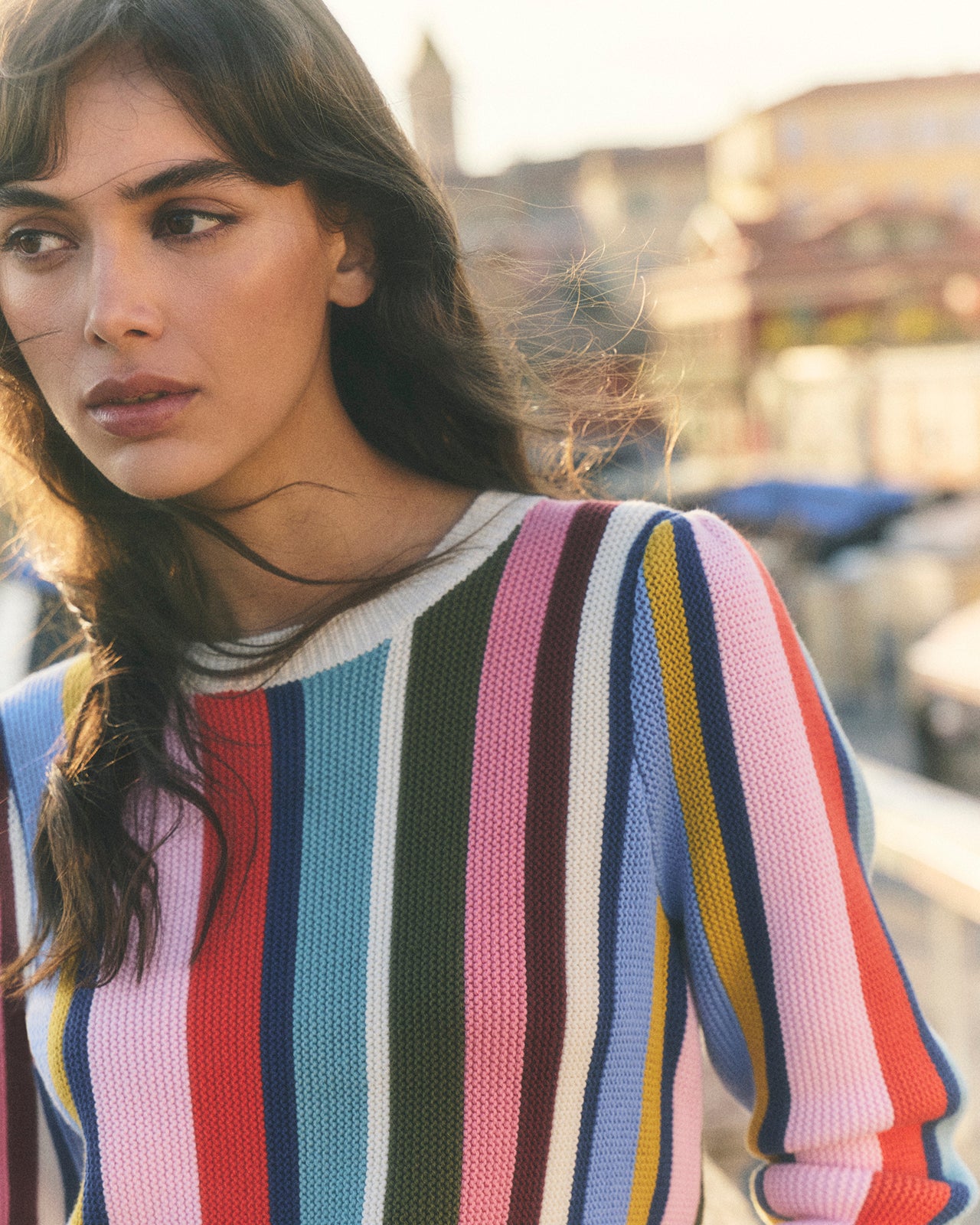 Woman wearing a colorful striped sweater with a blurred background