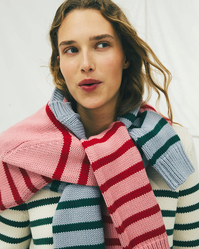 Woman wearing a colorful striped scarf with a white background