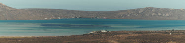 Lagoon surrounded by desert landscape with mountains in the background