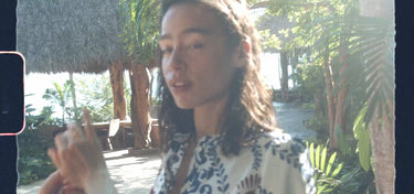Woman holding a phone with a tropical outdoor setting