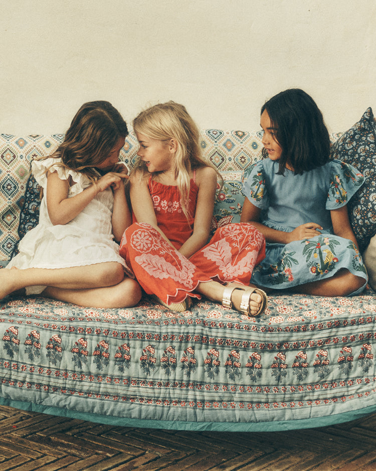 Three young girls sitting on a patterned couch
