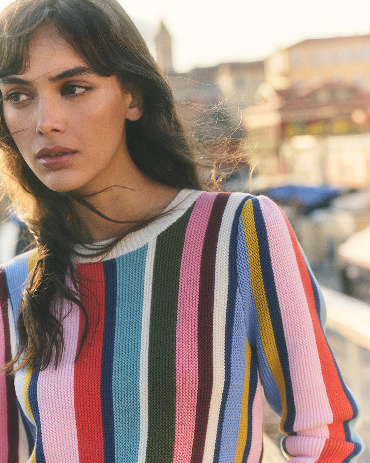 Woman wearing a colorful striped sweater with a blurred background