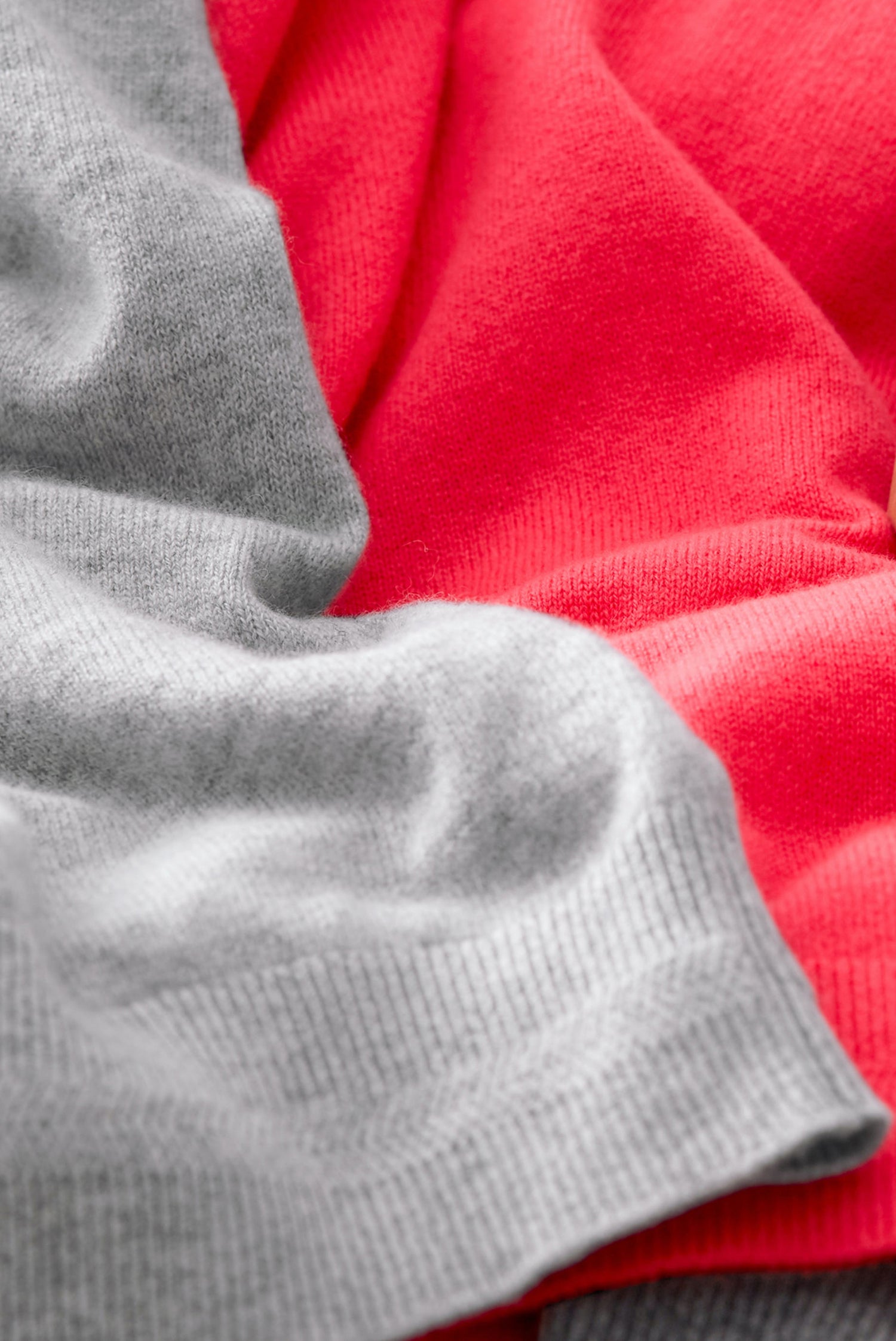 Close up of a grey, and a pink cashmere jumper